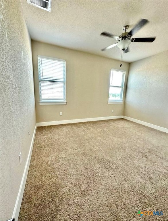 carpeted empty room with a textured ceiling and ceiling fan