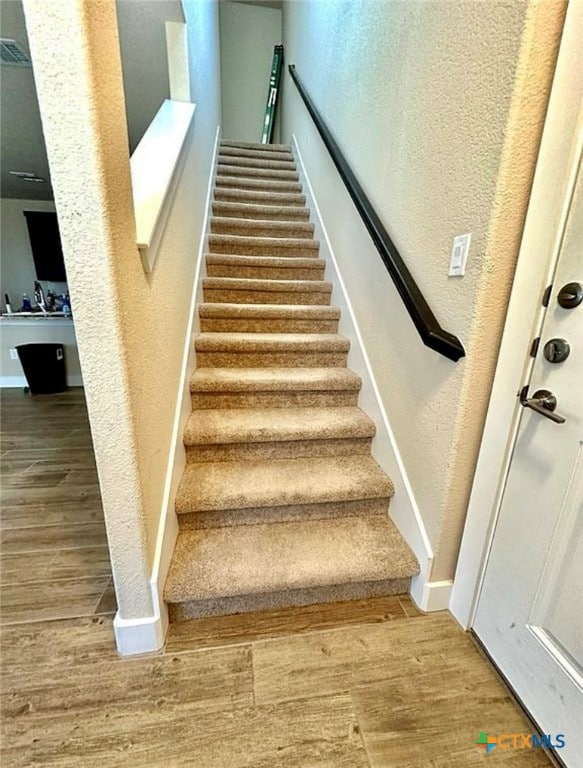 stairway with hardwood / wood-style flooring