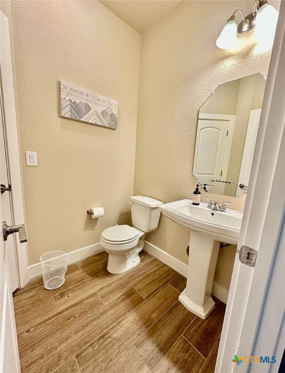 bathroom featuring wood-type flooring and toilet