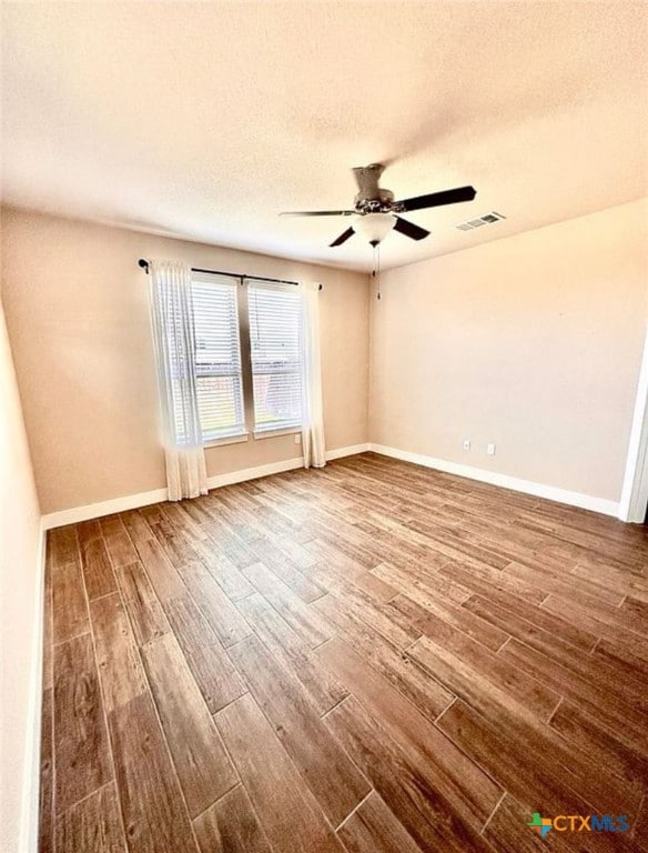 empty room with hardwood / wood-style floors, ceiling fan, and a textured ceiling