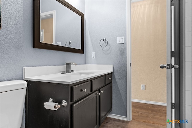 5300 Two Step Pl, Killeen, TX 76542 - bathroom featuring wood finished floors, toilet, vanity, baseboards, and a textured wall