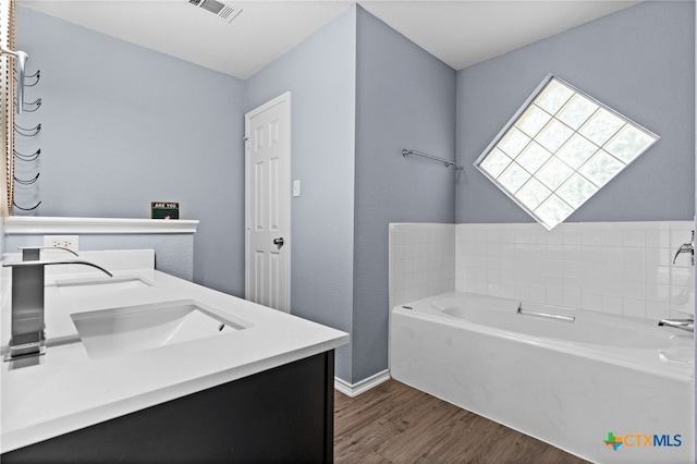 5300 Two Step Pl, Killeen, TX 76542 - bathroom with wood finished floors, a bath, double vanity, and baseboards