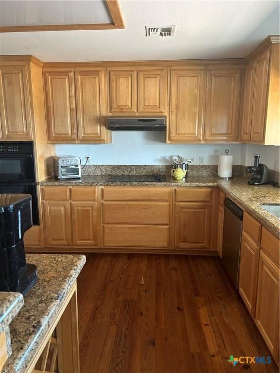 kitchen with visible vents, dark wood-type flooring, extractor fan, stone counters, and black appliances