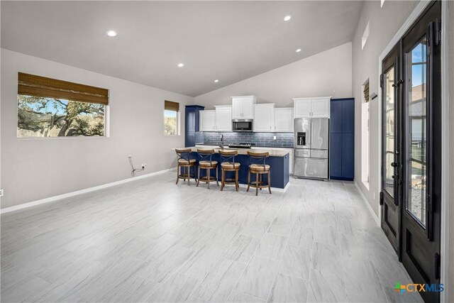 111 Western Oaks, New Braunfels, TX 78132 - kitchen with french doors, stainless steel appliances, a breakfast bar, decorative backsplash, and white cabinets