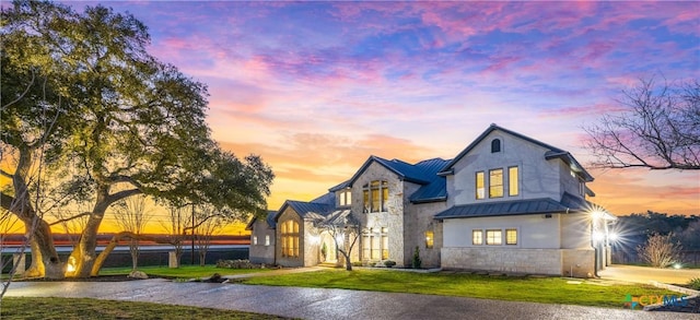 111 Western Oaks, New Braunfels, TX 78132 - view of front facade with stone siding, a lawn, a standing seam roof, and metal roof