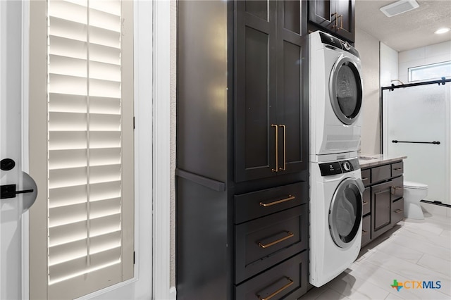 111 Western Oaks, New Braunfels, TX 78132 - laundry area with a textured ceiling, visible vents, marble finish floor, stacked washer / drying machine, and cabinet space