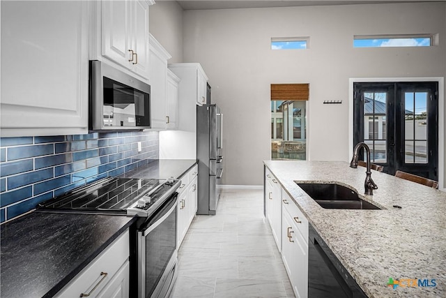 111 Western Oaks, New Braunfels, TX 78132 - kitchen featuring white cabinets, light stone countertops, tasteful backsplash, appliances with stainless steel finishes, and a sink