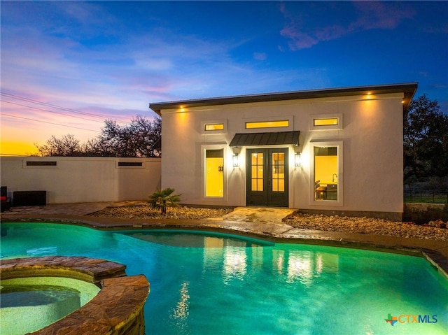 111 Western Oaks, New Braunfels, TX 78132 - back of property at dusk with stucco siding, french doors, and a pool with connected hot tub