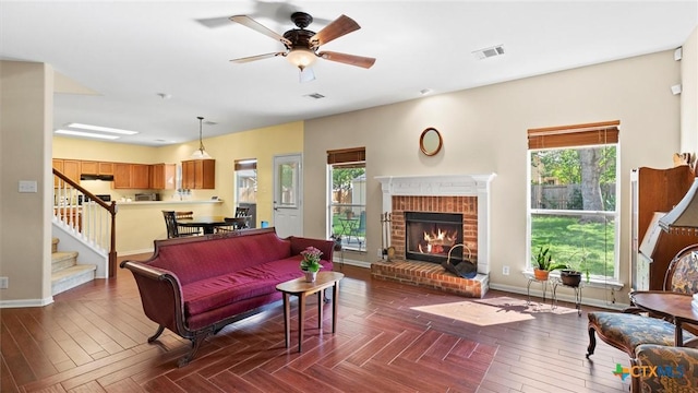 living area featuring plenty of natural light, baseboards, a fireplace, and stairs