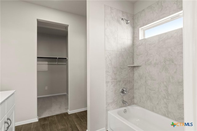1211 N Teychas Dr, Kyle, TX 78640 - full bathroom with vanity, tub / shower combination, wood finished floors, baseboards, and a spacious closet