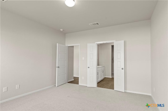 1211 N Teychas Dr, Kyle, TX 78640 - unfurnished bedroom featuring baseboards, visible vents, carpet, and ensuite bath