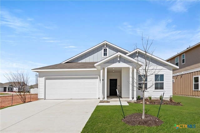 1211 N Teychas Dr, Kyle, TX 78640 - view of front of house with board and batten siding, driveway, a front lawn, and a garage
