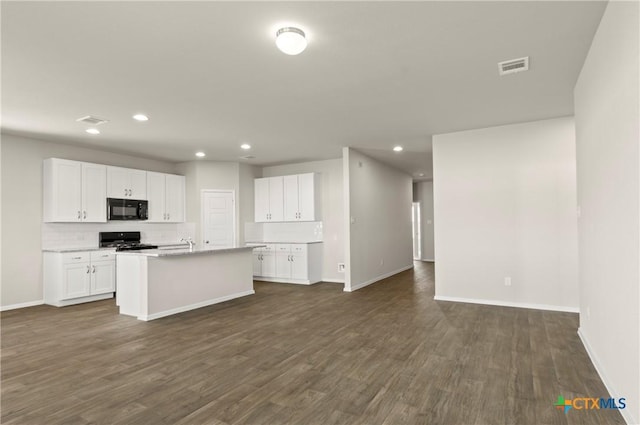 1211 N Teychas Dr, Kyle, TX 78640 - kitchen with black microwave, gas stove, visible vents, and tasteful backsplash