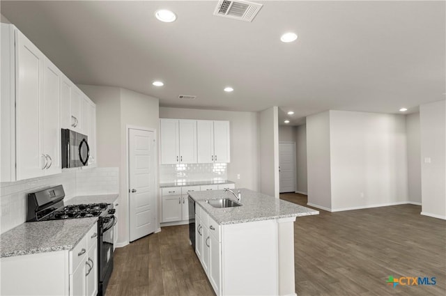 1211 N Teychas Dr, Kyle, TX 78640 - kitchen featuring a sink, a kitchen island with sink, decorative backsplash, visible vents, and black appliances