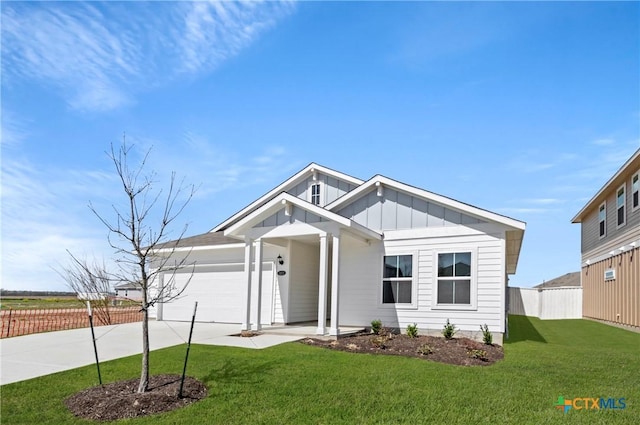 1211 N Teychas Dr, Kyle, TX 78640 - view of front of home featuring a garage, a front lawn, fence, board and batten siding, and driveway
