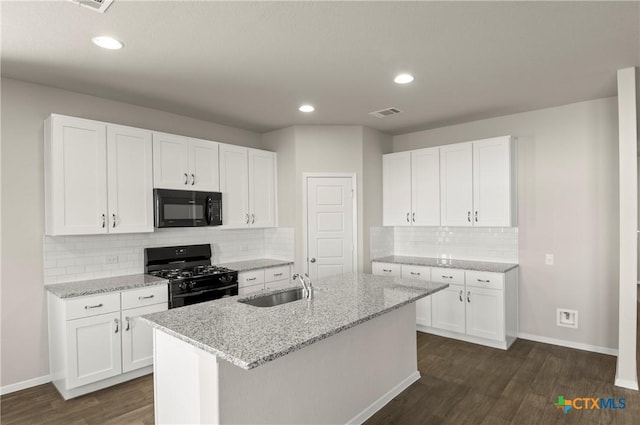 1211 N Teychas Dr, Kyle, TX 78640 - kitchen featuring dark wood-style flooring, a sink, baseboards, tasteful backsplash, and black appliances