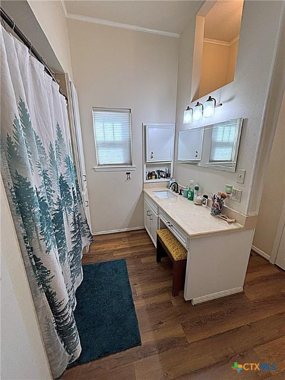 bathroom with vanity, wood finished floors, and ornamental molding