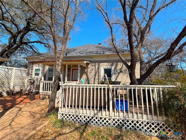 view of front of home featuring a deck and a shingled roof