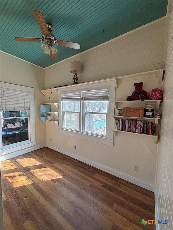 unfurnished room with a ceiling fan, baseboards, and wood finished floors