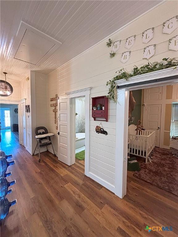 hallway with wooden ceiling, attic access, and wood finished floors