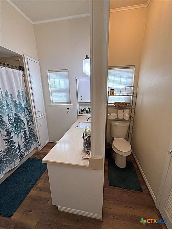 full bath featuring curtained shower, baseboards, toilet, ornamental molding, and wood finished floors