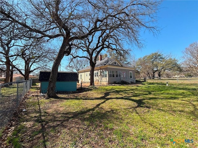 view of yard with an outbuilding, a shed, and a fenced backyard