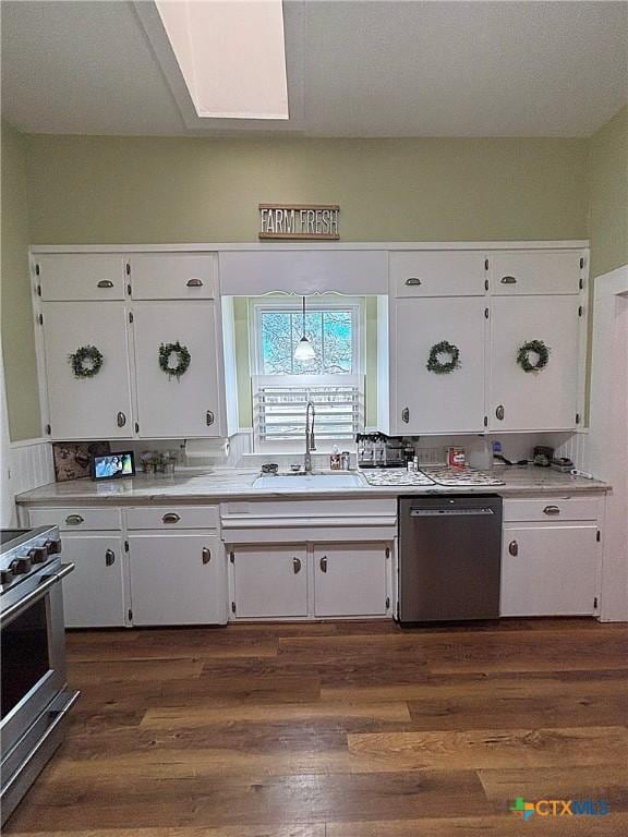 kitchen with white cabinets, dark wood-style floors, appliances with stainless steel finishes, and a sink