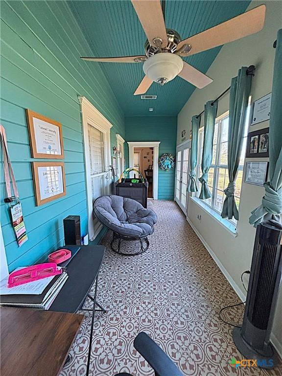 sunroom / solarium featuring a ceiling fan