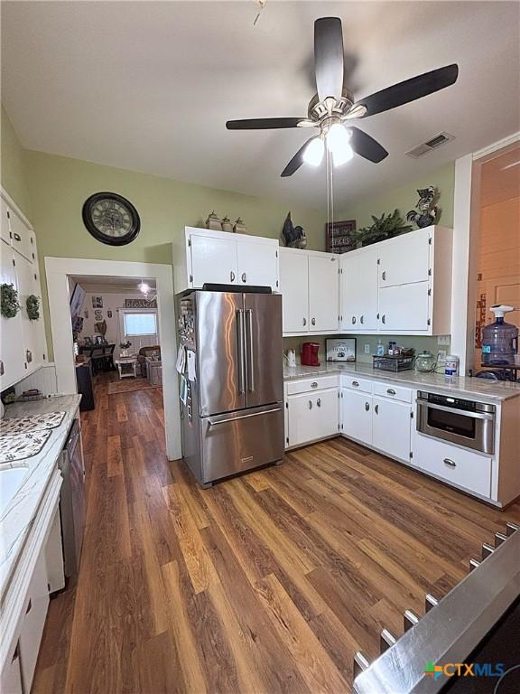 kitchen with visible vents, dark wood finished floors, light countertops, appliances with stainless steel finishes, and white cabinetry