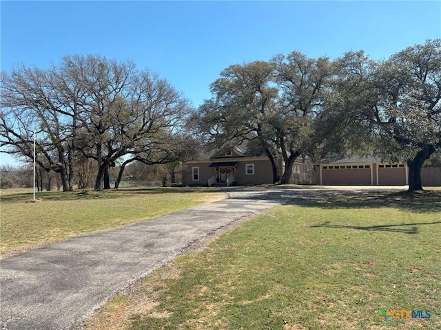 view of front of home with a front lawn, a garage, and driveway