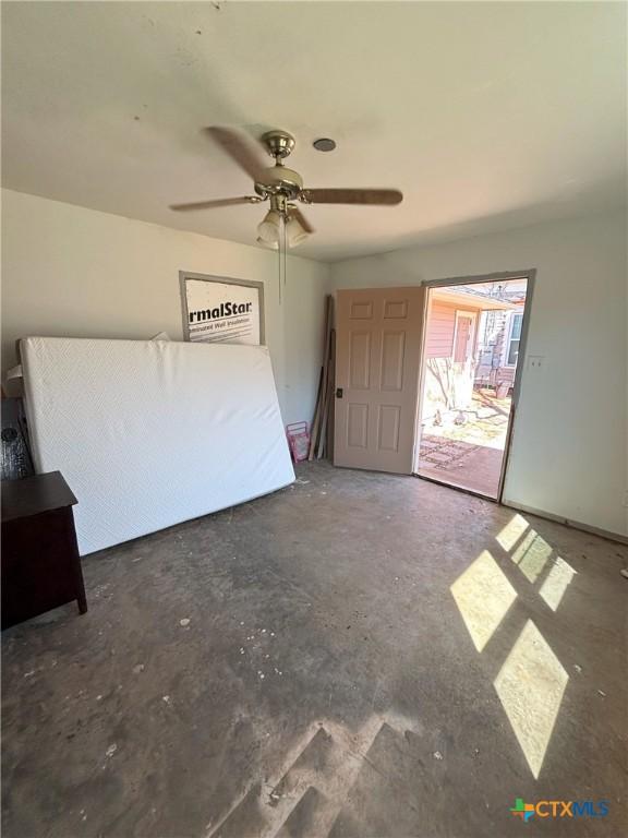 unfurnished bedroom featuring concrete floors and a ceiling fan