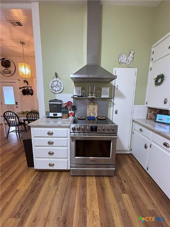 kitchen featuring stainless steel range with electric cooktop, white cabinetry, dark wood-type flooring, and wall chimney range hood