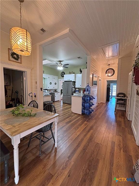 dining room featuring attic access, wooden ceiling, visible vents, and dark wood-style flooring