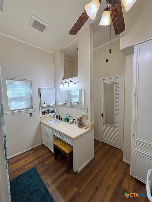 bathroom with vanity, wood finished floors, baseboards, visible vents, and ceiling fan