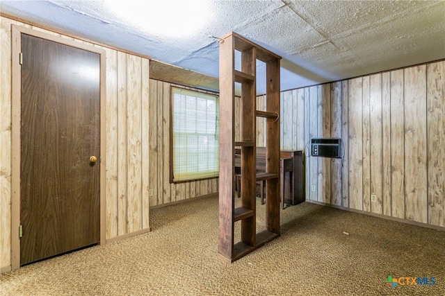 interior space featuring wood walls, carpet, and a textured ceiling