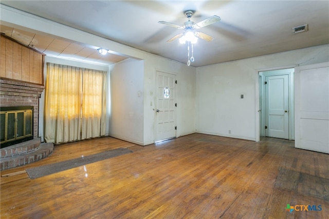 unfurnished living room featuring dark hardwood / wood-style flooring, ceiling fan, and a fireplace