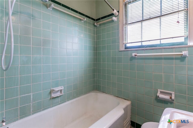 bathroom featuring toilet and tiled shower / bath combo