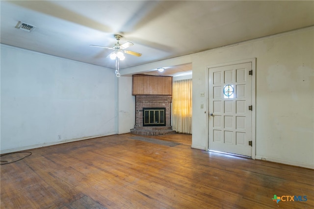 unfurnished living room featuring a brick fireplace, wood-type flooring, and ceiling fan