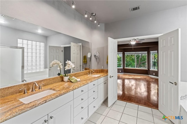 bathroom with tile patterned floors, ceiling fan, a bathtub, and vanity