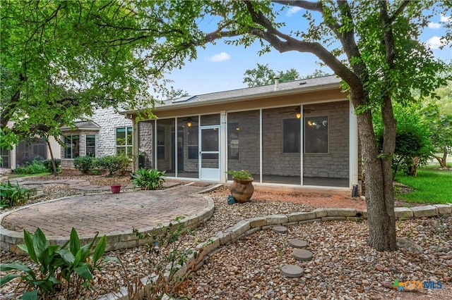 rear view of property with a sunroom and a patio