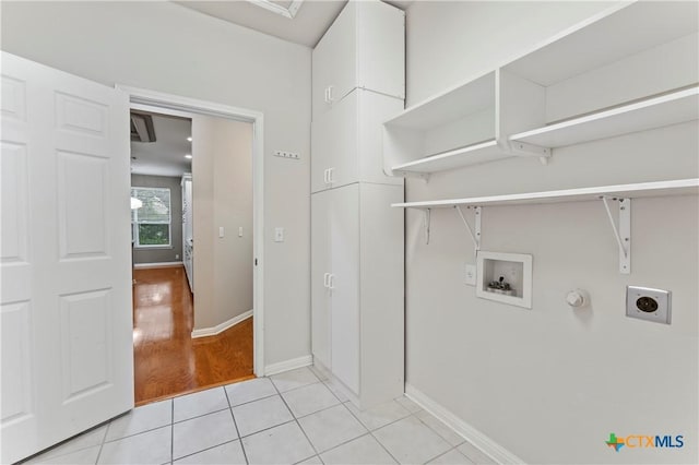 washroom featuring hookup for an electric dryer, hookup for a gas dryer, light tile patterned floors, and hookup for a washing machine