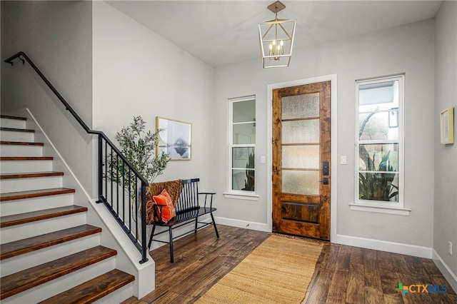 foyer featuring a chandelier, stairway, wood finished floors, and baseboards