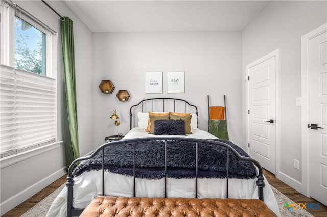 bedroom with wood finished floors and baseboards