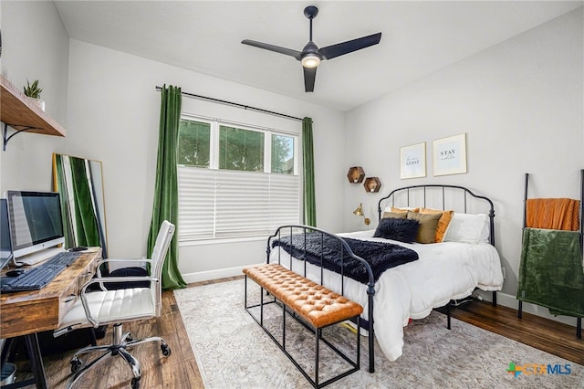 bedroom featuring ceiling fan, wood finished floors, and baseboards