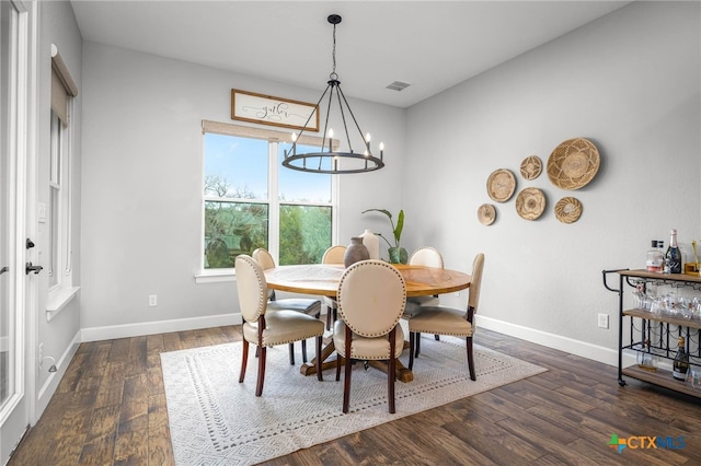 dining room with dark wood-style floors, baseboards, and a notable chandelier