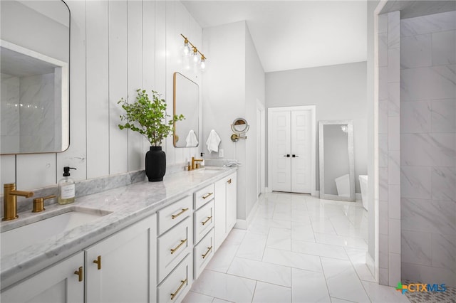 full bath with marble finish floor, double vanity, a shower, and a sink