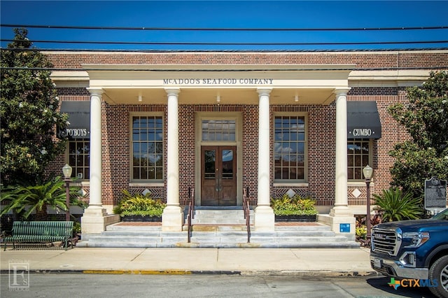 doorway to property featuring french doors and brick siding