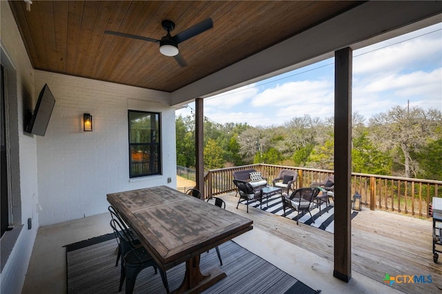 wooden deck featuring an outdoor living space and a ceiling fan