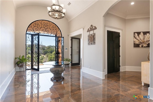 entryway featuring arched walkways, crown molding, visible vents, and baseboards