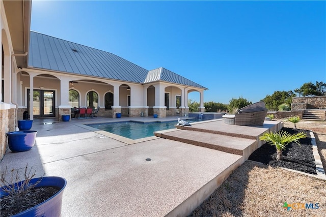 outdoor pool with french doors and a patio area